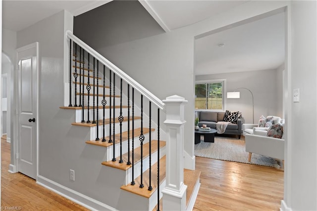 stairway with baseboards and wood finished floors
