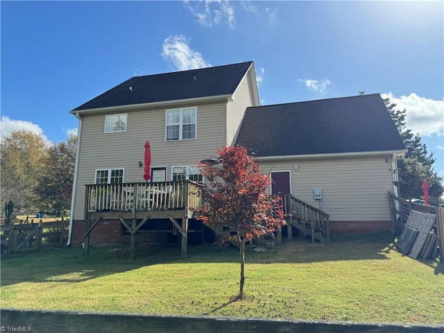 back of property featuring a wooden deck and a lawn