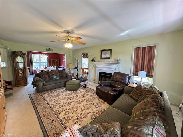 carpeted living room featuring ceiling fan and a fireplace