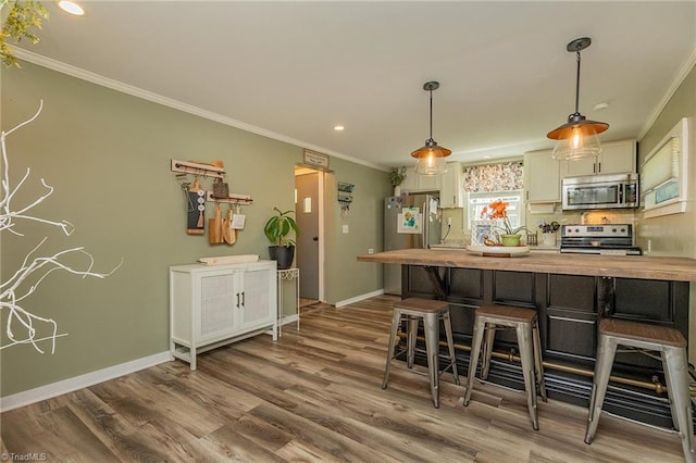 1055 Old Silver Hill Rd, Lexington, NC 27292 - kitchen with stainless steel appliances, ornamental molding, dark wood-type flooring, a kitchen breakfast bar, and recessed lighting