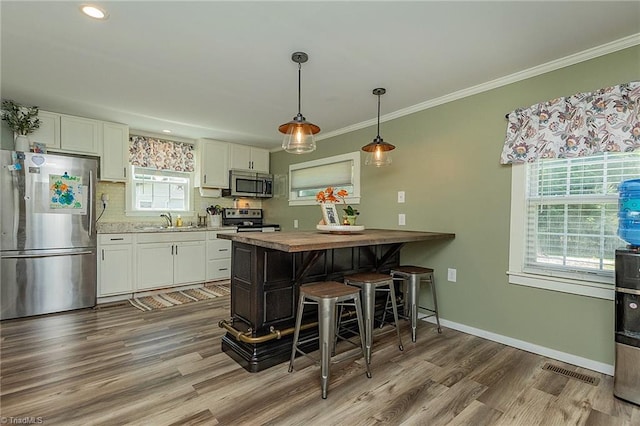 1055 Old Silver Hill Rd, Lexington, NC 27292 - kitchen with stainless steel appliances, white cabinets, a kitchen bar, a sink, and wood finished floors