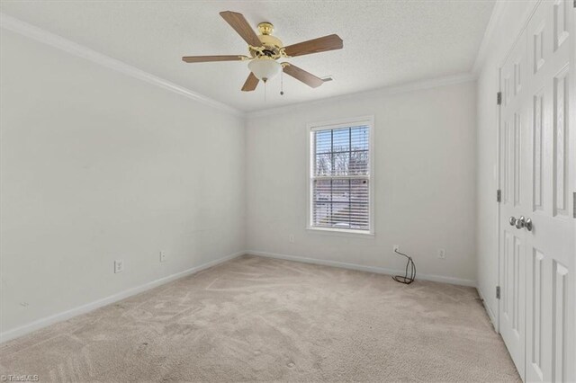 unfurnished bedroom with ceiling fan, light colored carpet, and crown molding