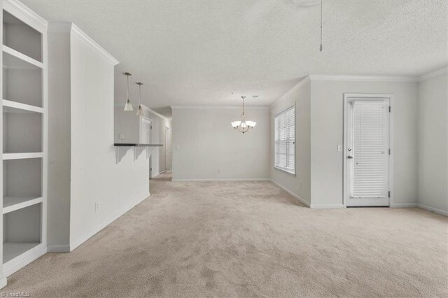 unfurnished living room with light carpet, a textured ceiling, and ornamental molding