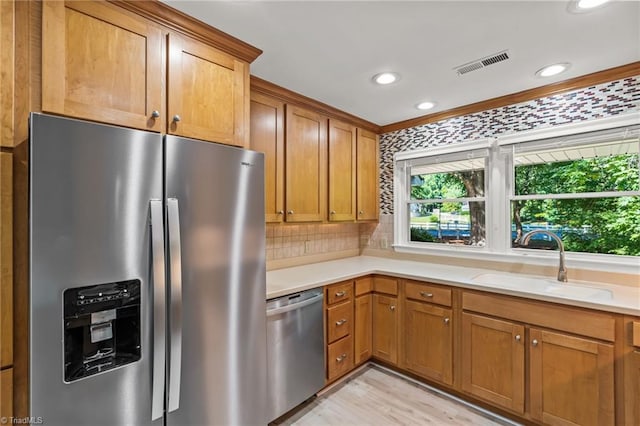 800 Carriage Crossing Ln Unit E, Greensboro, NC 27410 - kitchen with appliances with stainless steel finishes, recessed lighting, light countertops, brown cabinetry, and light wood-style flooring