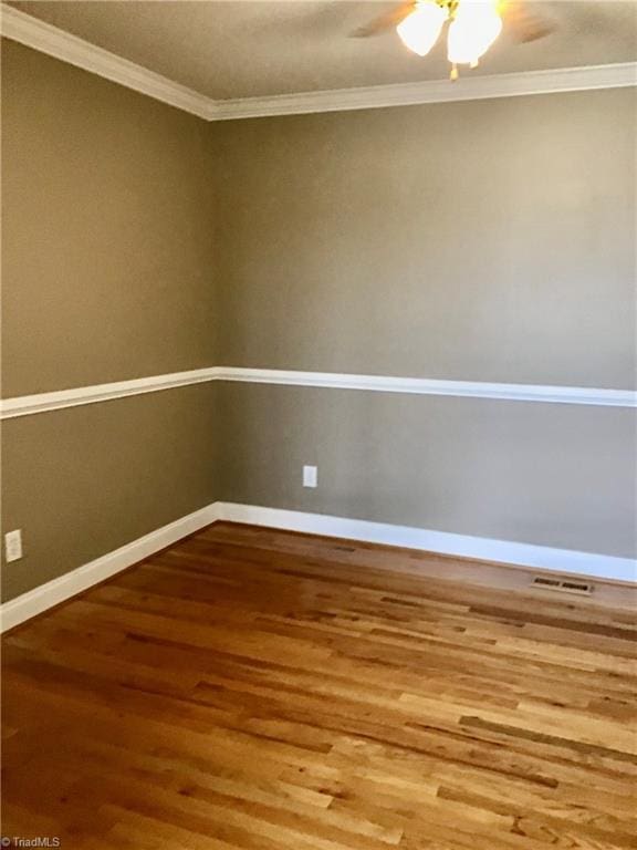 unfurnished room with ceiling fan, crown molding, wood finished floors, and baseboards