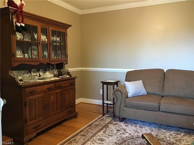 bar with light wood finished floors, baseboards, and crown molding