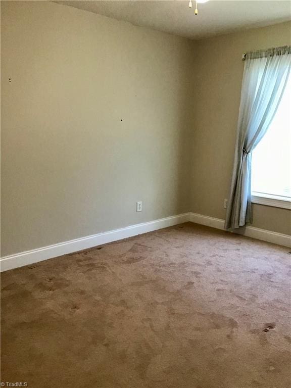 spare room with carpet flooring and baseboards