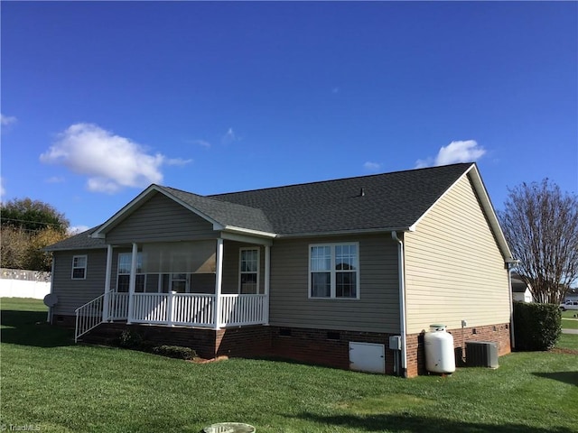 back of house with crawl space, a sunroom, central air condition unit, and a yard