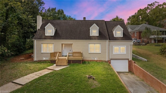 cape cod home featuring a yard and a garage