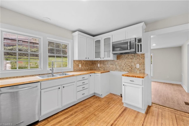 kitchen with light hardwood / wood-style flooring, stainless steel appliances, sink, and white cabinetry