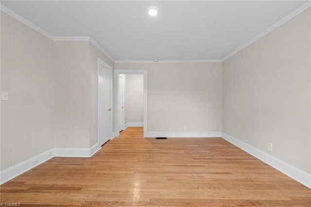 spare room featuring crown molding and light hardwood / wood-style floors