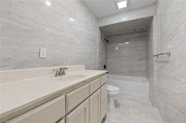 full bathroom with vanity, toilet, tile walls, and tiled shower / bath