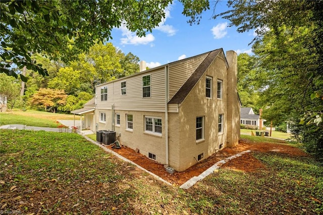 rear view of property featuring cooling unit and a yard