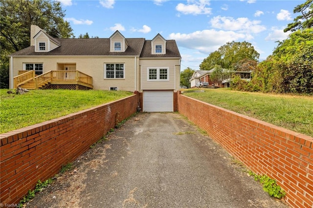 cape cod home featuring a garage and a front lawn