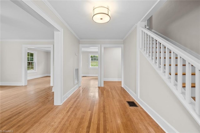 entrance foyer featuring ornamental molding and light hardwood / wood-style floors