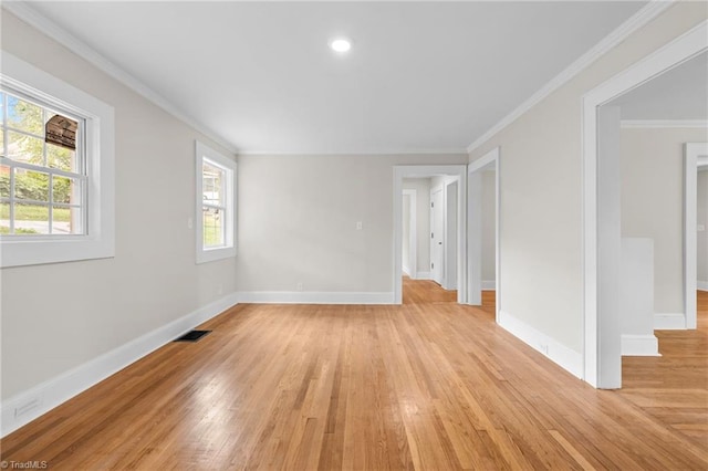 empty room with light hardwood / wood-style floors and crown molding