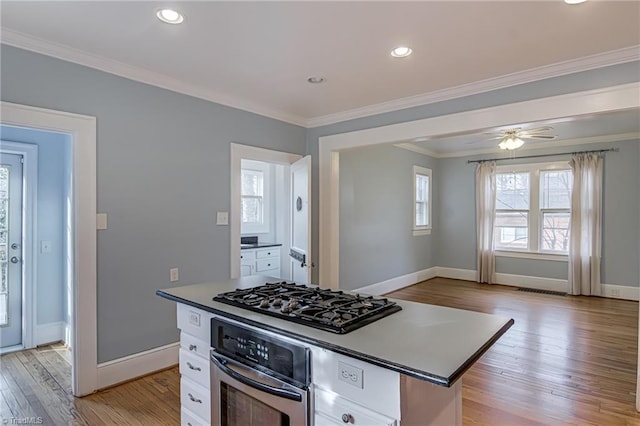 kitchen featuring oven, ornamental molding, light wood-style flooring, black gas stovetop, and white cabinetry