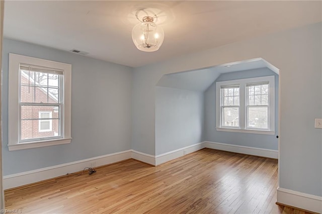 bonus room with a wealth of natural light, visible vents, baseboards, and light wood-style floors