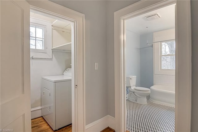 laundry room with laundry area, washer / dryer, baseboards, and visible vents