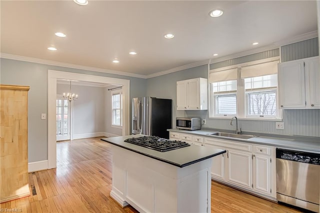 kitchen with white cabinetry, a chandelier, appliances with stainless steel finishes, and a sink