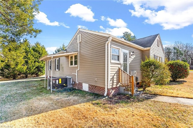 view of property exterior with central AC and a lawn