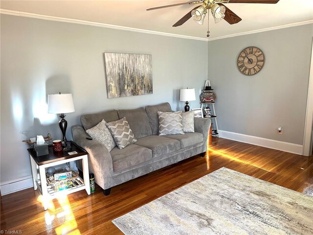 living room with dark hardwood / wood-style flooring, crown molding, and ceiling fan