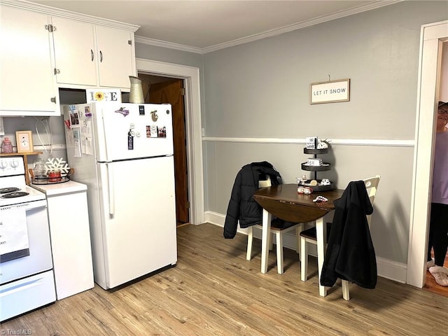 kitchen with white appliances, light hardwood / wood-style flooring, ornamental molding, and white cabinets