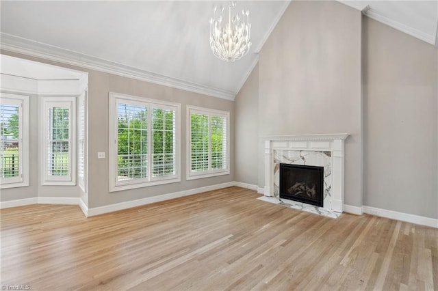 unfurnished living room with vaulted ceiling, healthy amount of natural light, a fireplace, ornamental molding, and wood finished floors