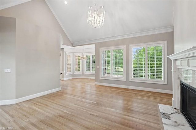 unfurnished living room featuring baseboards, ornamental molding, a fireplace, a chandelier, and lofted ceiling
