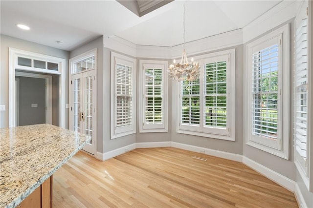 unfurnished dining area featuring baseboards, a chandelier, healthy amount of natural light, light wood-type flooring, and recessed lighting