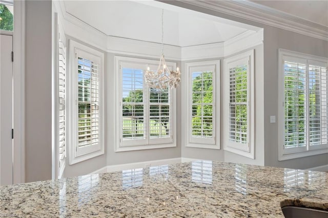 unfurnished dining area with a chandelier, ornamental molding, and plenty of natural light