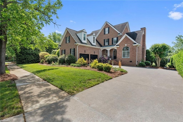 traditional-style house featuring brick siding, a garage, driveway, and a front lawn