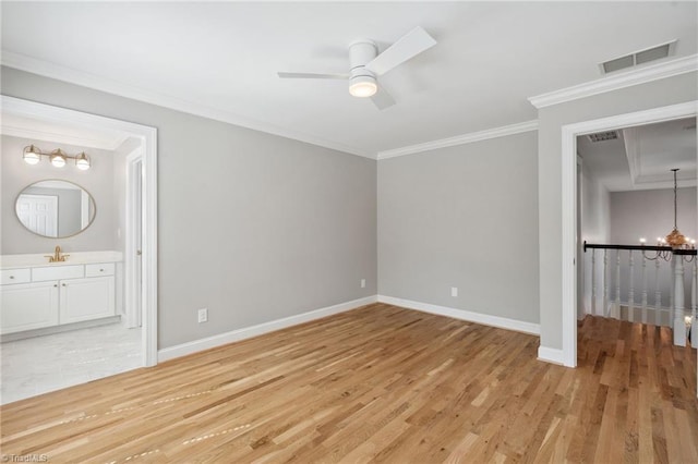 unfurnished bedroom featuring crown molding, light wood-style floors, baseboards, a chandelier, and ensuite bathroom