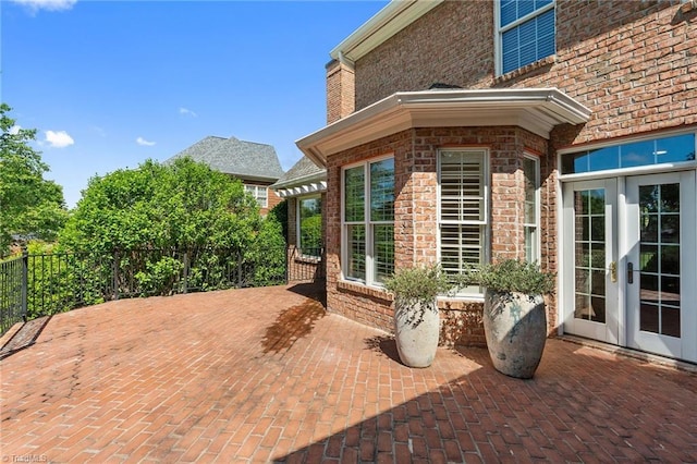 view of patio with french doors and fence