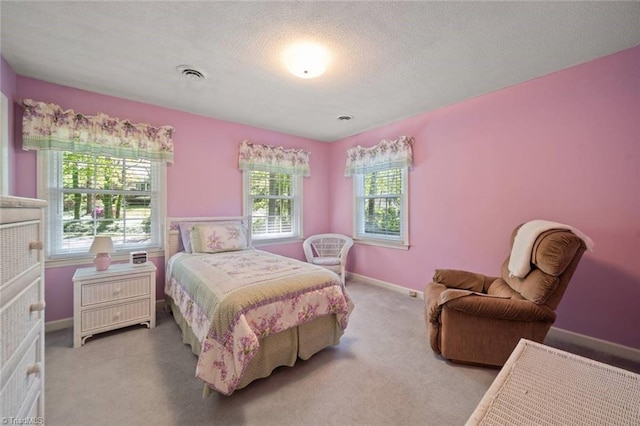 carpeted bedroom with baseboards, visible vents, and a textured ceiling