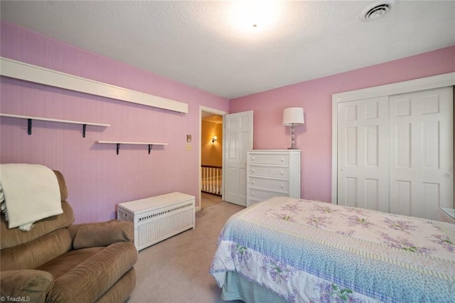 carpeted bedroom with a closet and visible vents
