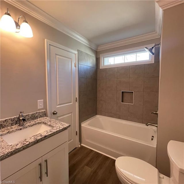 full bathroom featuring vanity, crown molding, wood-type flooring, toilet, and tiled shower / bath