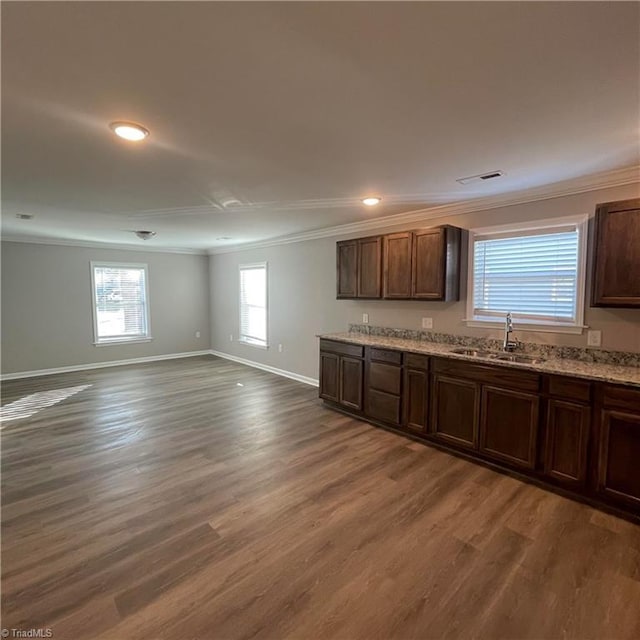 kitchen with dark brown cabinets, ornamental molding, sink, and dark wood-type flooring