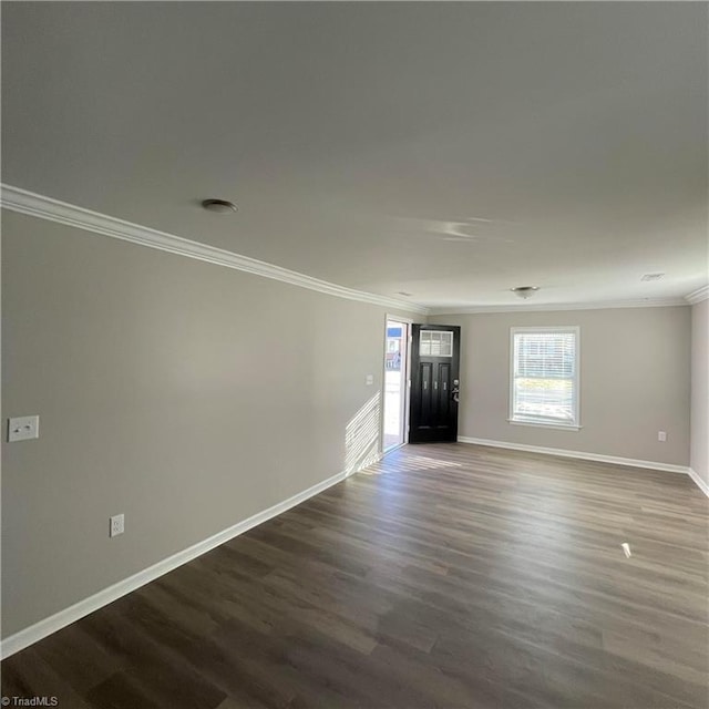 unfurnished room featuring dark wood-type flooring and ornamental molding