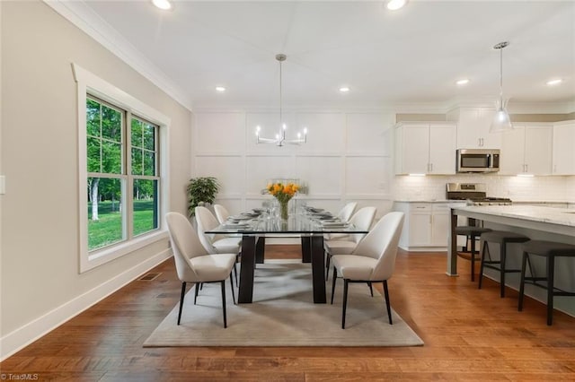 dining room with ornamental molding, a wealth of natural light, and light hardwood / wood-style floors