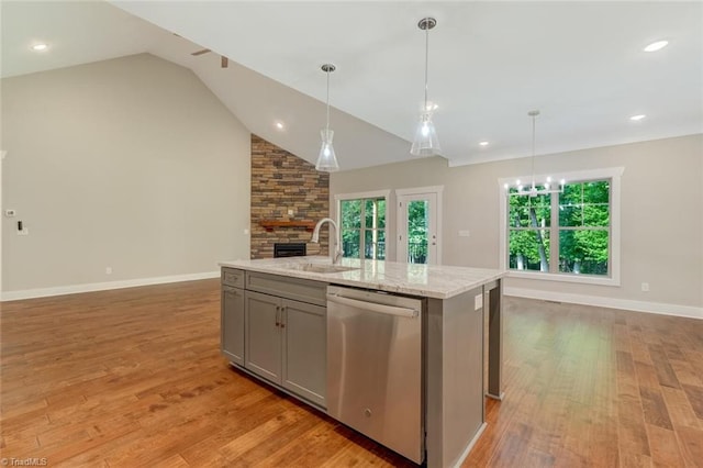 kitchen featuring dishwasher, hardwood / wood-style flooring, a kitchen island with sink, and vaulted ceiling