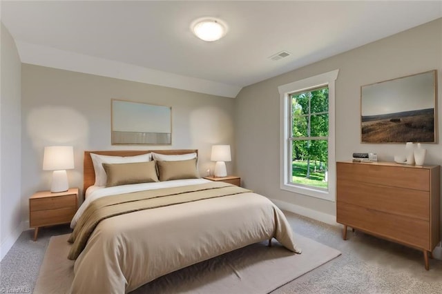 bedroom with lofted ceiling and light colored carpet