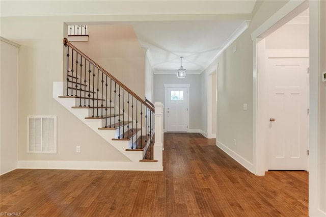 foyer with crown molding and wood-type flooring