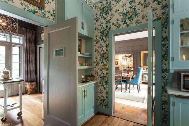 interior space featuring light wood-type flooring, green cabinets, and built in shelves