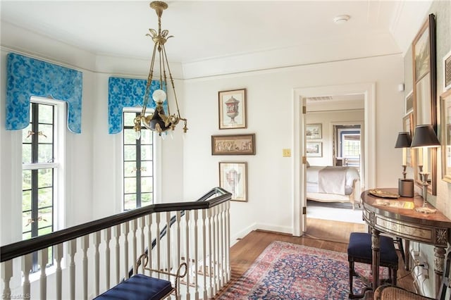 hallway featuring an inviting chandelier and hardwood / wood-style flooring