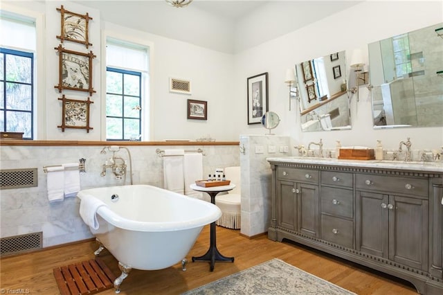 bathroom with hardwood / wood-style flooring, tile walls, plenty of natural light, and vanity