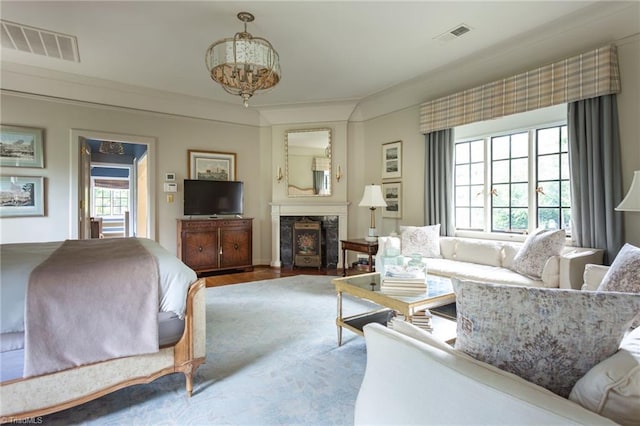 living room with hardwood / wood-style floors, an inviting chandelier, and a high end fireplace