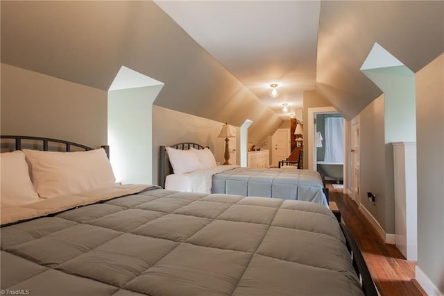 bedroom with lofted ceiling and dark hardwood / wood-style floors