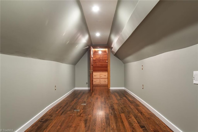 additional living space with vaulted ceiling and dark hardwood / wood-style floors