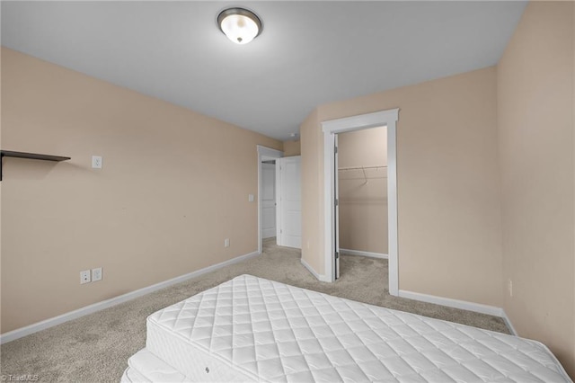 carpeted bedroom with vaulted ceiling, a walk in closet, and a closet